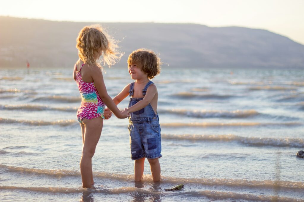 Children holding hands on the beach